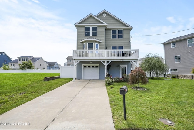 view of front of home with concrete driveway, an attached garage, fence, and a front lawn