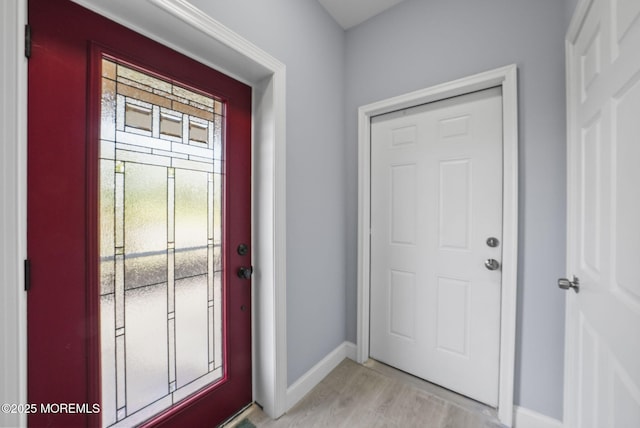 foyer entrance with baseboards and light wood-type flooring