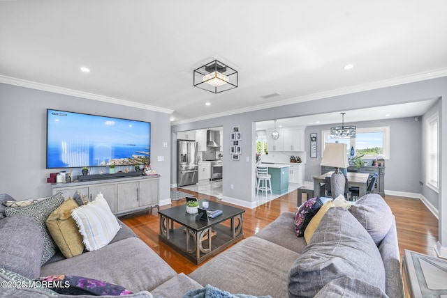 living area featuring ornamental molding, baseboards, and wood finished floors