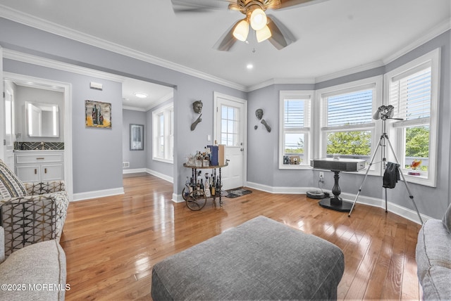 interior space featuring baseboards, wood-type flooring, and ornamental molding