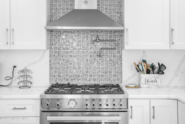 kitchen featuring backsplash, white cabinetry, high end stainless steel range, and wall chimney range hood