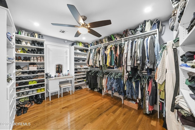 spacious closet with visible vents, ceiling fan, and wood finished floors