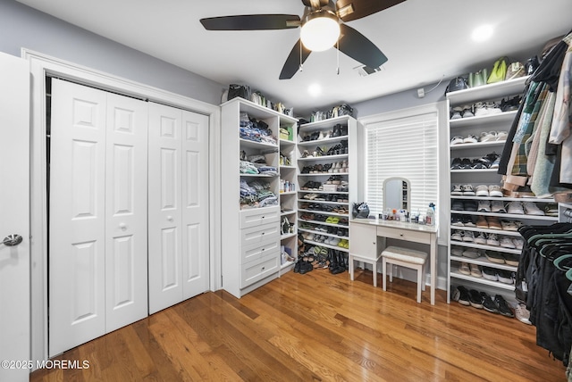 walk in closet with wood finished floors