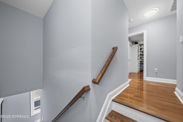 stairs featuring visible vents, wood finished floors, and baseboards