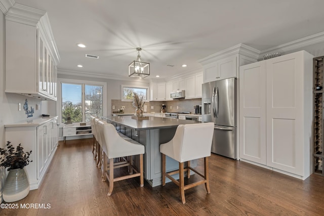 kitchen with visible vents, dark wood-style floors, white cabinetry, appliances with stainless steel finishes, and decorative backsplash