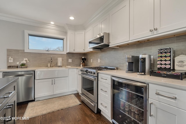 kitchen featuring crown molding, beverage cooler, appliances with stainless steel finishes, dark wood-style floors, and a sink