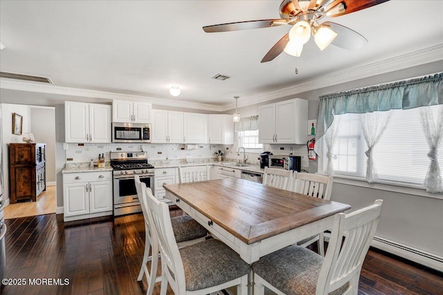 kitchen featuring a baseboard heating unit, dark wood-style floors, a sink, and stainless steel appliances