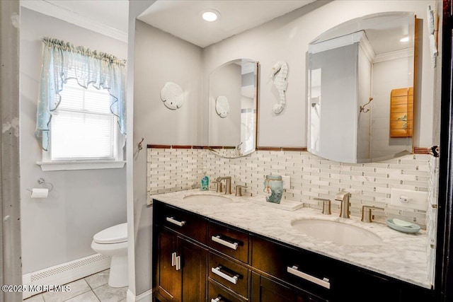 full bathroom featuring backsplash, a baseboard heating unit, toilet, tile patterned floors, and a sink