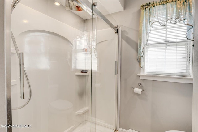 bathroom featuring toilet and a shower stall