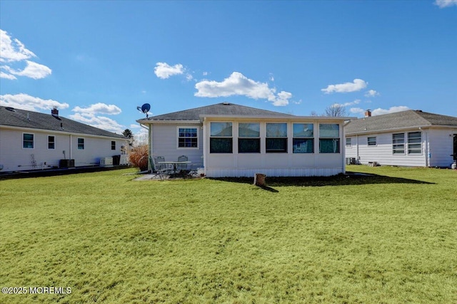 rear view of property featuring a yard and central AC