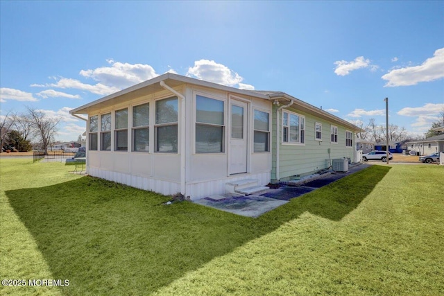 exterior space featuring entry steps, a yard, and central AC