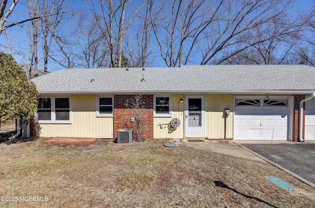 ranch-style house featuring central AC unit, driveway, a shingled roof, and a garage