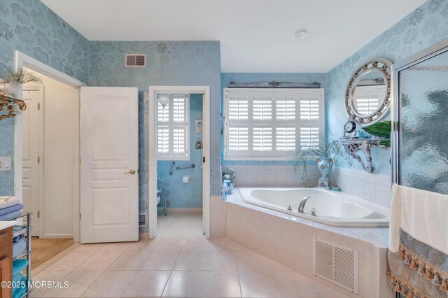 bathroom featuring wallpapered walls, tile patterned floors, a bath, and visible vents