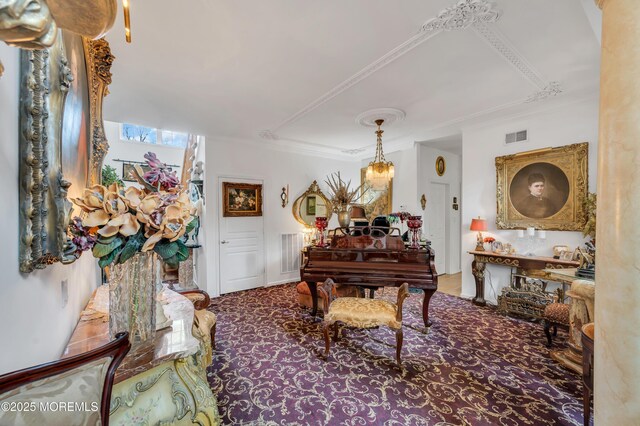 living area with visible vents and crown molding