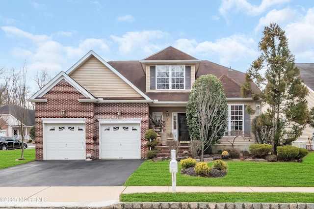 view of front of house with brick siding, aphalt driveway, a front yard, and an attached garage