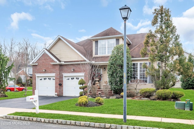 view of front of home featuring a front lawn, an attached garage, brick siding, and driveway