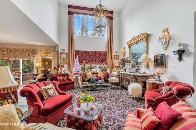 living room with a wealth of natural light, a chandelier, visible vents, and a towering ceiling