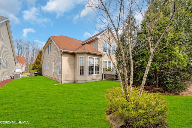 back of house featuring a lawn and central AC