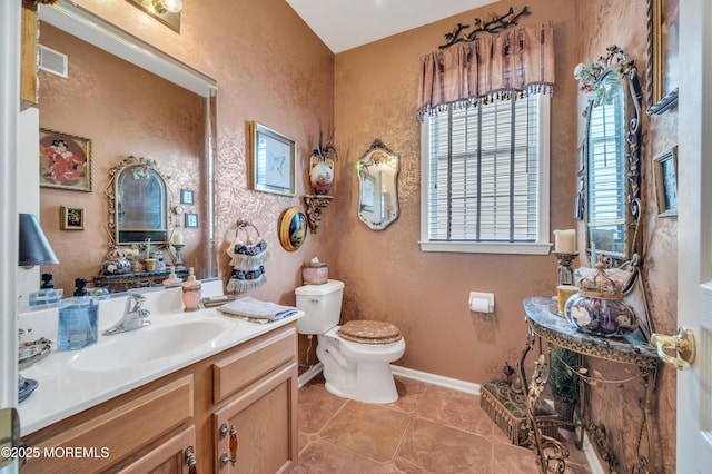 bathroom featuring visible vents, baseboards, toilet, tile patterned floors, and vanity