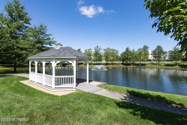 view of dock featuring a gazebo, a yard, and a water view