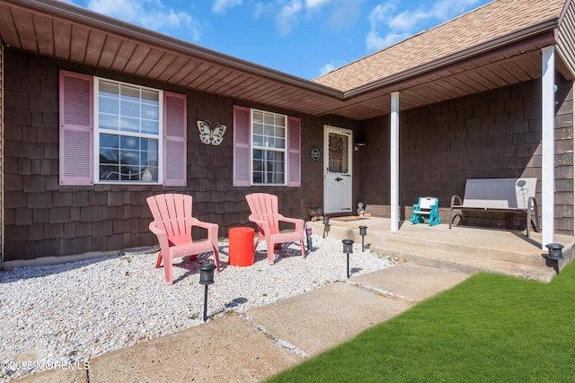 doorway to property with a shingled roof