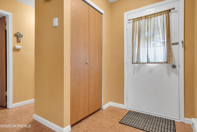 foyer featuring baseboards and light wood-type flooring