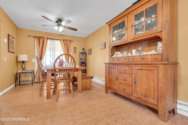 dining area featuring baseboards, light wood-style floors, and a ceiling fan