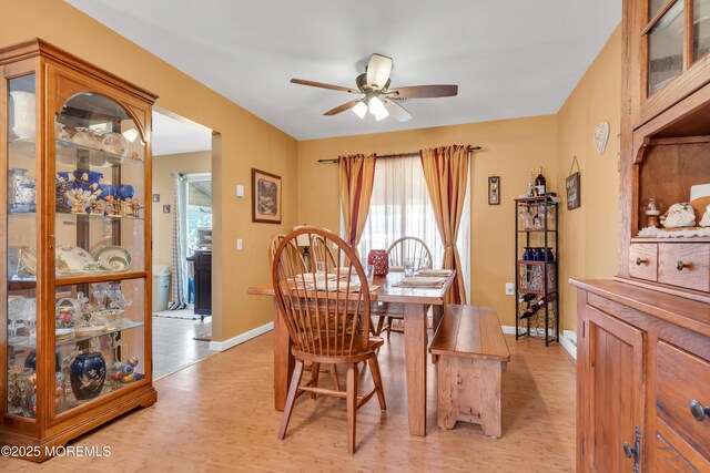 dining room with baseboards, light wood-style flooring, and a ceiling fan