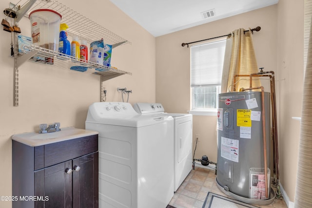 washroom with visible vents, electric water heater, and washing machine and dryer