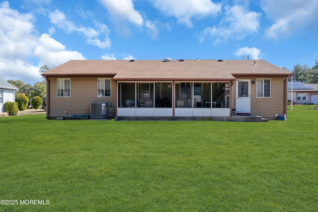 back of property with a yard, cooling unit, a sunroom, and a shingled roof