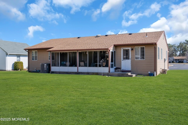 back of property with a yard, roof with shingles, cooling unit, and a sunroom