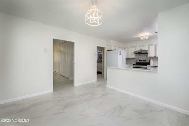 interior space with marble finish floor, electric stove, under cabinet range hood, freestanding refrigerator, and decorative backsplash