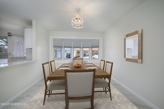 dining room with baseboards, marble finish floor, and a healthy amount of sunlight