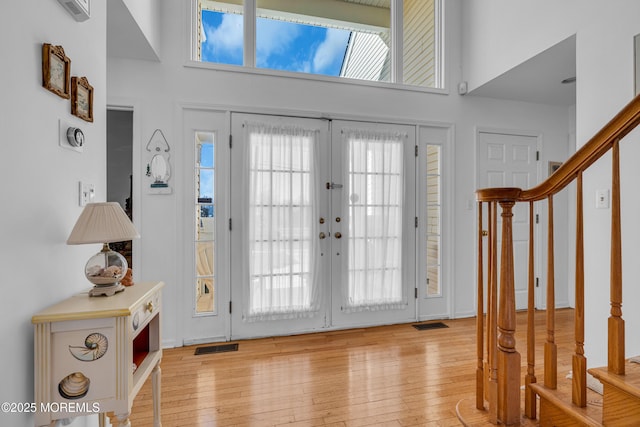 foyer featuring plenty of natural light, stairway, and light wood-type flooring