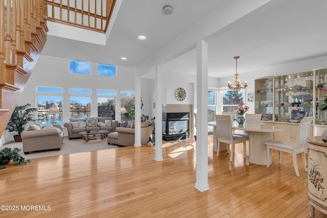 living room with a chandelier, recessed lighting, a fireplace, and light wood-style floors