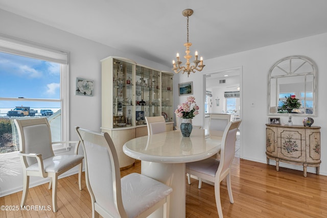 dining area with an inviting chandelier, light wood-style floors, visible vents, and a healthy amount of sunlight