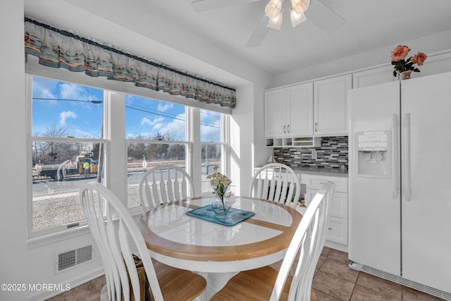 dining room with light tile patterned floors, visible vents, and ceiling fan