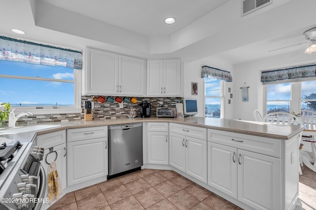 kitchen with a peninsula, tasteful backsplash, visible vents, and appliances with stainless steel finishes