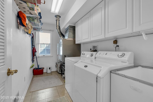 washroom with a sink, baseboards, cabinet space, and washing machine and clothes dryer