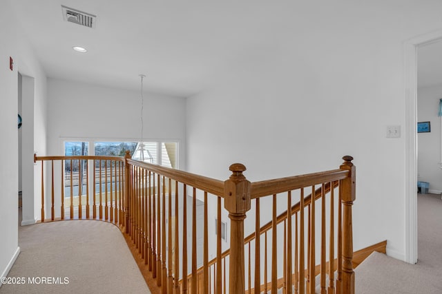 corridor featuring visible vents, carpet floors, baseboards, recessed lighting, and an upstairs landing