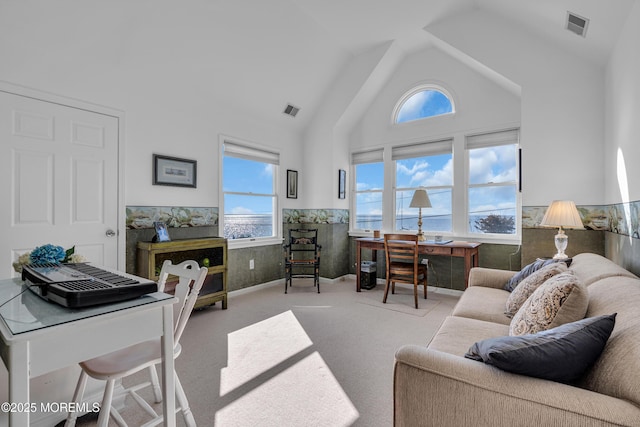 carpeted living room with a wealth of natural light, a wainscoted wall, and visible vents