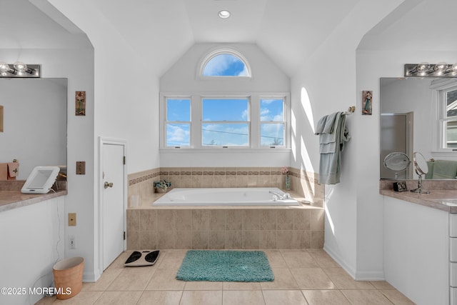 full bath featuring a shower stall, a garden tub, lofted ceiling, tile patterned floors, and vanity