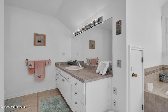 bathroom featuring tile patterned flooring, vanity, a relaxing tiled tub, and vaulted ceiling