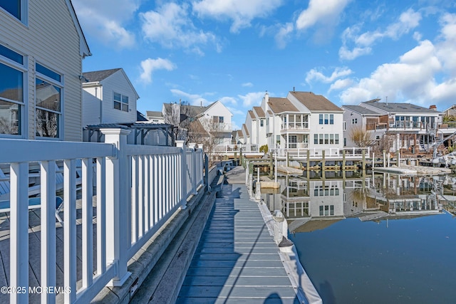 view of dock with a residential view and a water view