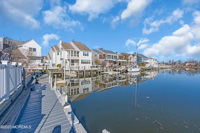 dock area with a residential view and a water view