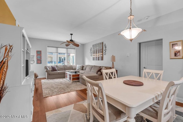 dining space with baseboards, ceiling fan, and hardwood / wood-style flooring