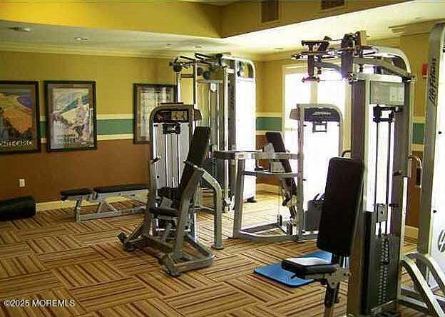 workout area with carpet flooring and ornamental molding