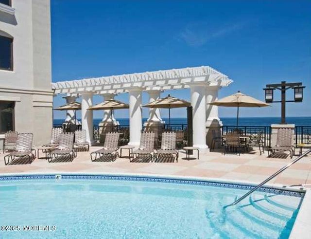 pool with a pergola, a patio, and fence