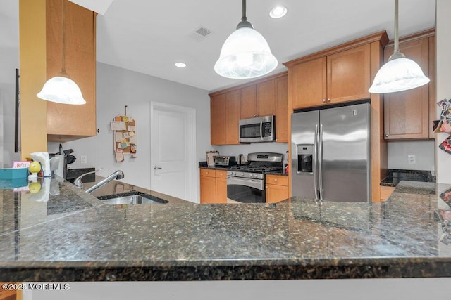 kitchen featuring visible vents, a peninsula, stainless steel appliances, and a sink