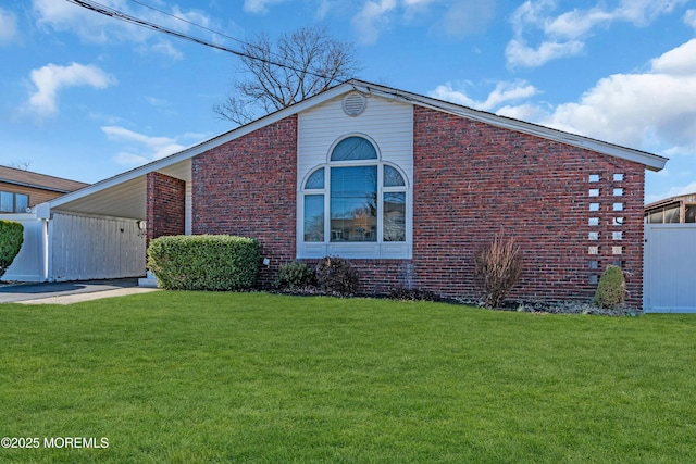 view of front of home with brick siding, a front yard, and fence